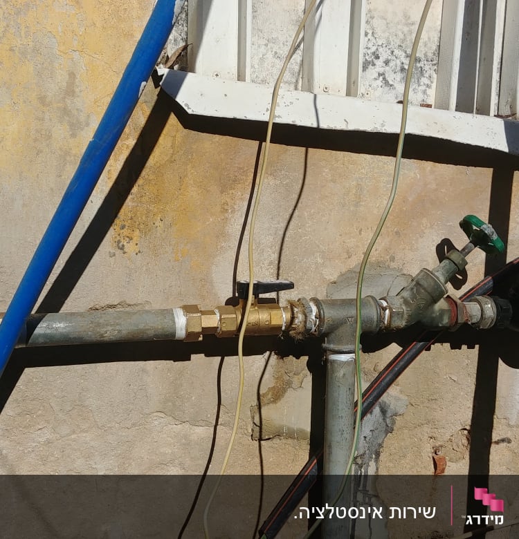 צינורות מים עם ברזים על קיר חיצוני